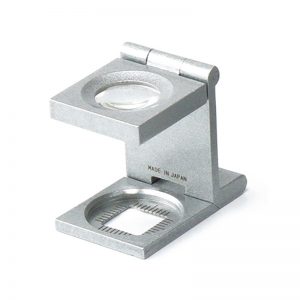 The classic Alfa Mirage folding loupe linen tester standing upright, showing its genuine Made in Japan engraving.