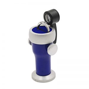 The blue JYBS diamond inscription viewer holding a silver engagement ring on its rotating cushioned platform stage.