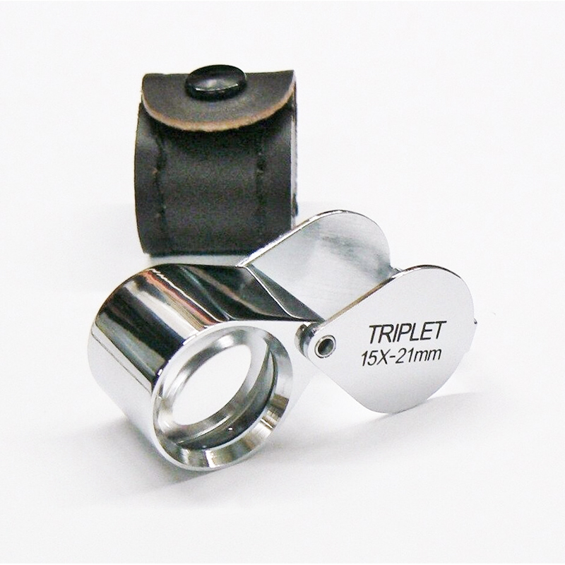 The fifteen times magnification JYBS diamond triplet loupe displayed alongside its custom protective leather snap-button carrying case. The fifteen times magnification JYBS diamond triplet loupe displayed alongside its custom protective leather snap-button carrying case.