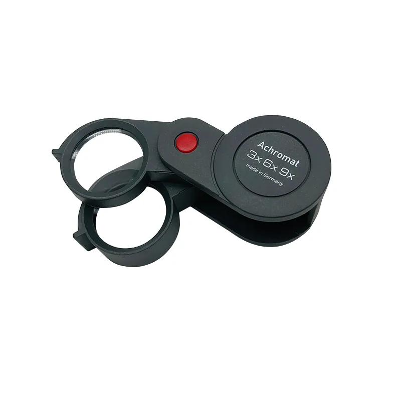 Top profile of the Eschenbach achromatic pocket magnifier highlighting the red hinge axis pin and dual lens swing path. Top profile of the Eschenbach achromatic pocket magnifier highlighting the red hinge axis pin and dual lens swing path.