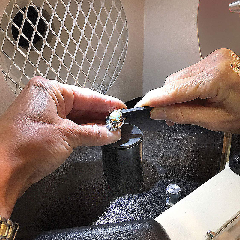 Hands working on a silver and opal ring inside the Foredom Work Chamber dust collector. Hands working on a silver and opal ring inside the Foredom Work Chamber dust collector.