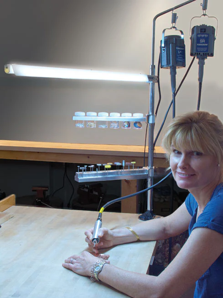 Jeweler working at bench with Foredom Work Bench System with motor hanger and storage arms. Jeweler working at bench with Foredom Work Bench System with motor hanger and storage arms.