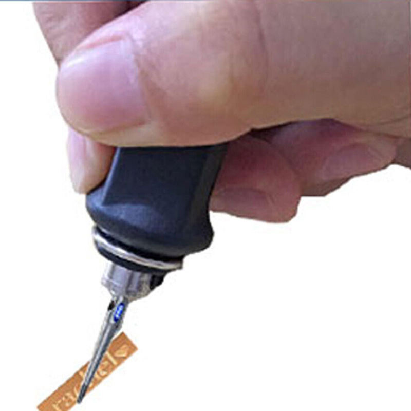 Hand holding a Foredom H.15 Hammer Handpiece with a stylus tip engraving a small, rectangular metal piece. Hand holding a Foredom H.15 Hammer Handpiece with a stylus tip engraving a small, rectangular metal piece.