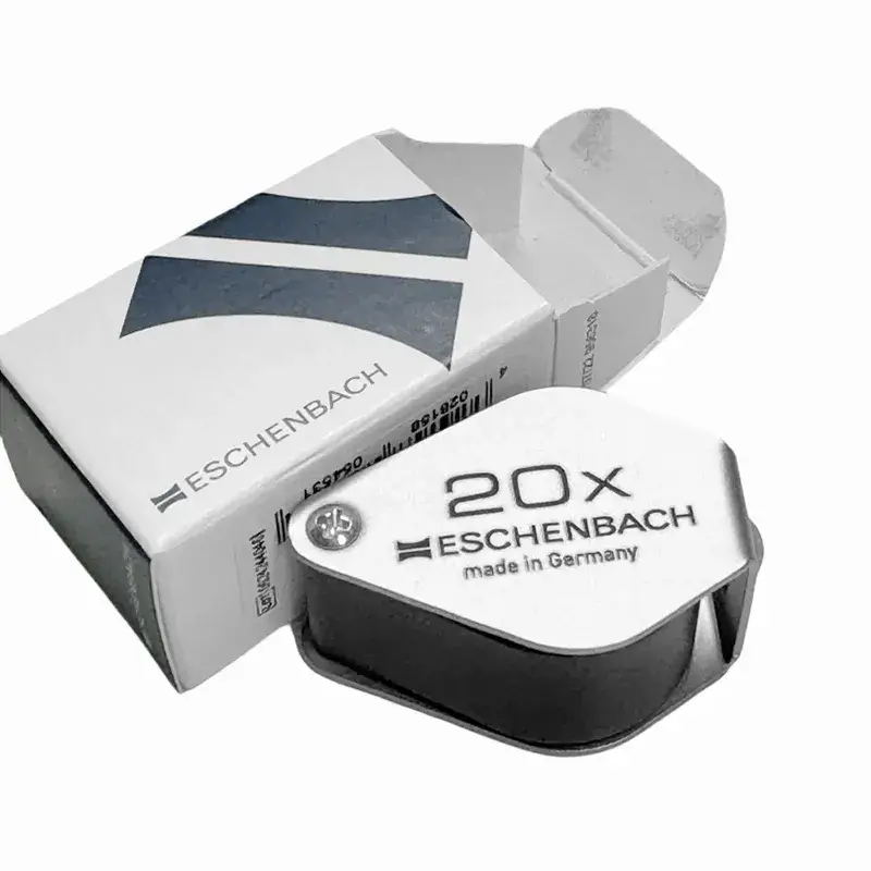 Eschenbach 20x triplet loupe, made in Germany, and its original packaging box, isolated on white.