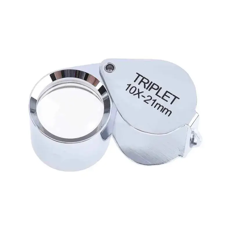 A classic silver chrome folding triplet loupe with 10X-21mm magnification text printed on its metal frame.