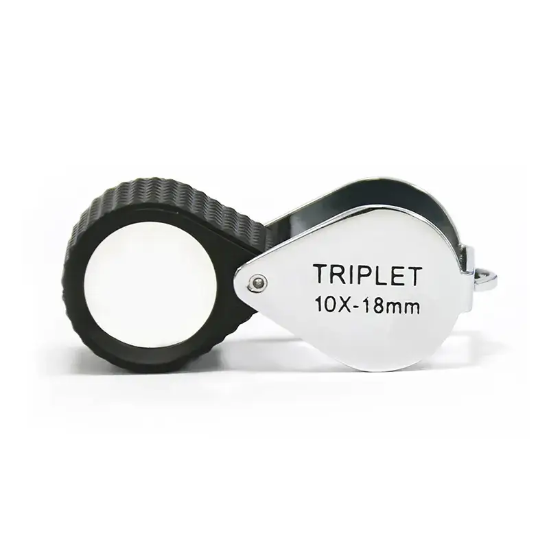 A folding silver 10X-18mm triplet loupe featuring a textured black rubberized protective grip.