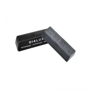 The authentic DIALUX Black (Noir) polishing compound bar resting in front of its signature black cardboard packaging box.