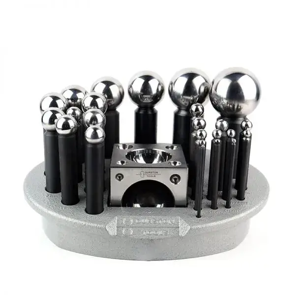 A premium Durston Tools steel dapping punch and die set organized on a heavy circular storage base for jewelry metal forming.