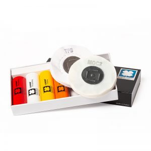 The complete LUXOR MERARD polishing kit displayed inside its open white presentation box with four color-coded bars and two stacked 4-inch buffing discs.