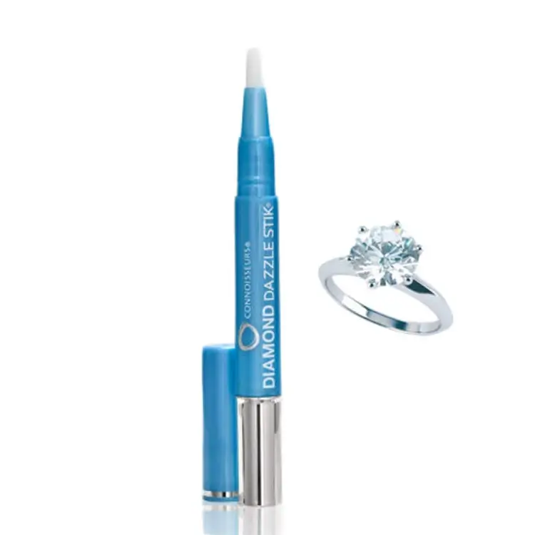 Connoisseurs Diamond Dazzle Stik cleaning brush pen next to a solitaire diamond ring.