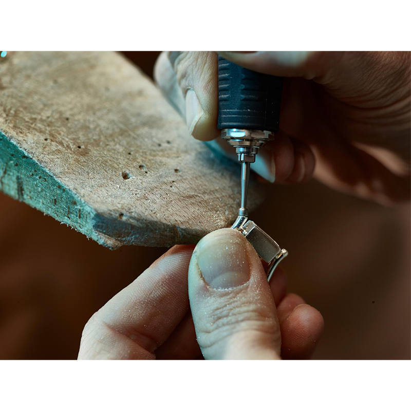 niqua® s(f) tool steel burs cup bur Rounding prong tips on a jewelry mount clamped at a wooden bench peg using an S(f) rotary cup bur.