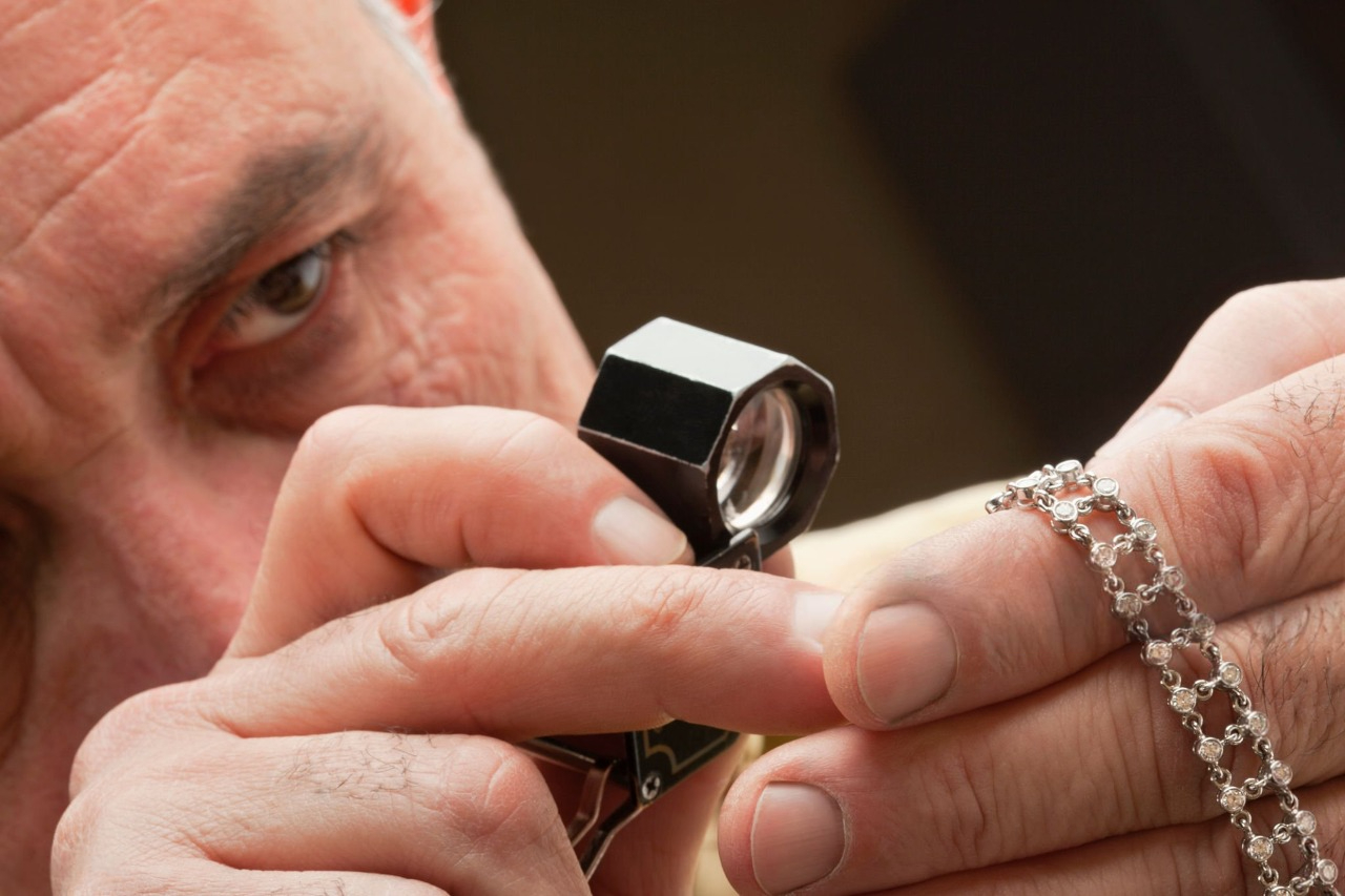 a jeweler using a loupe to inspect a diamond bracelet