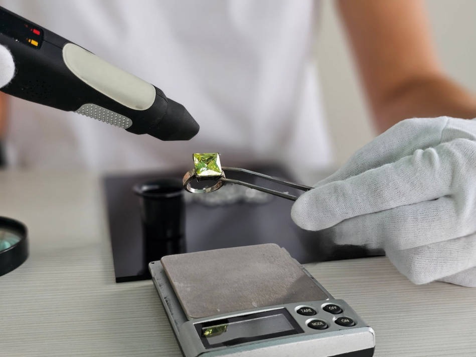 a jeweler examining a peridot ring