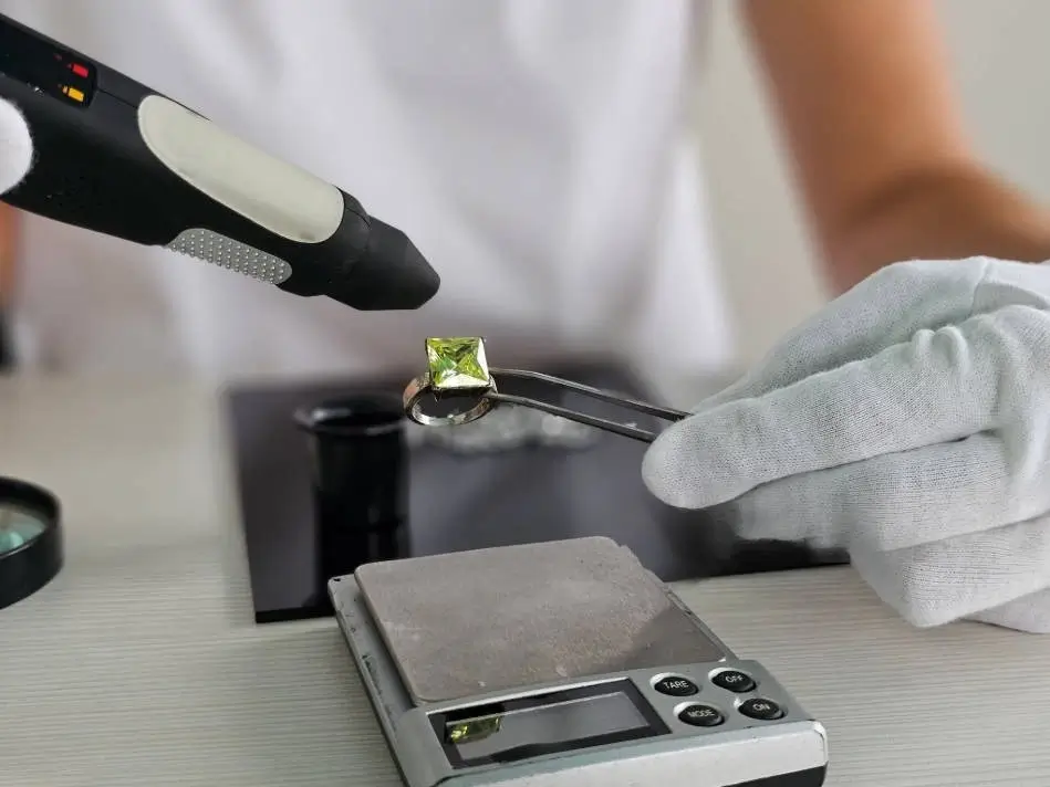 a jeweler examining a peridot ring