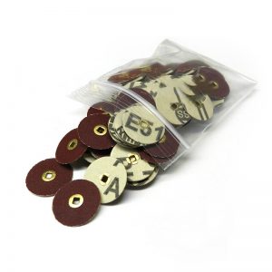 22mm premium aluminum oxide sanding discs with brass centers spilling from a clear plastic bag, showcasing various grits