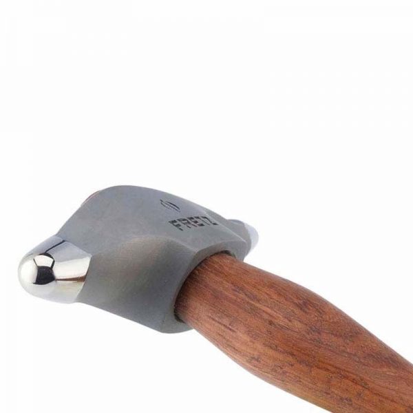 Angled close-up of the Fretz® Small Embossing Hammer's polished ball face and wooden handle, ready for detailed work