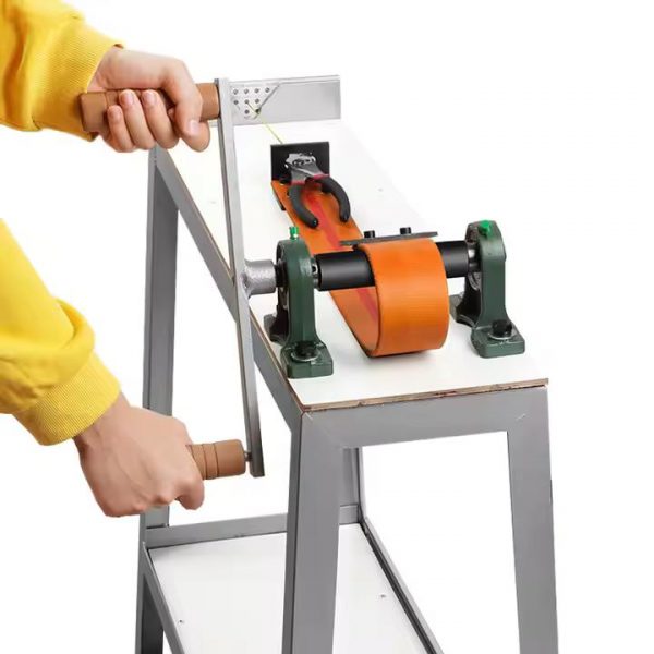 close up hands operating the high stand manual wire drawing bench with wire and pliers