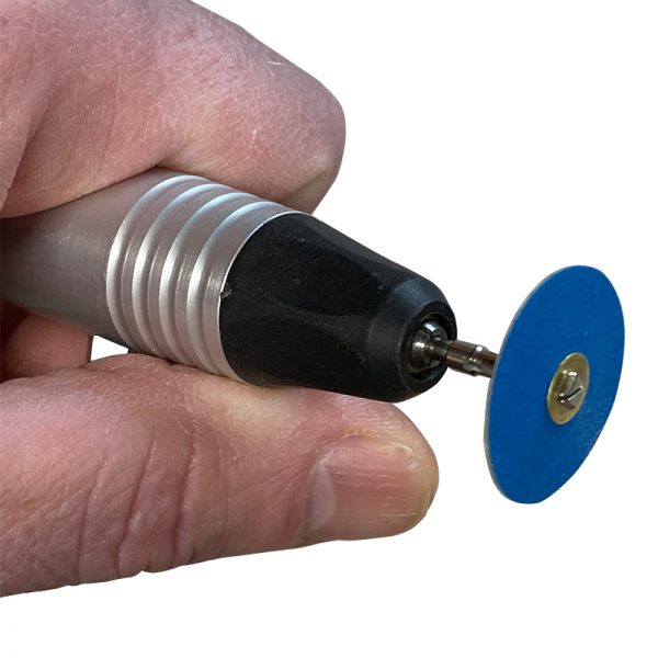 Hand holding a rotary tool with an attached 22mm 120# Zirconia Sanding Disc, brass center visible