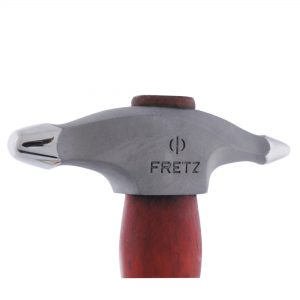 Close-up of a finely hammered golden metal surface, showcasing the detailed textures from the Fretz® Small Embossing Hammer