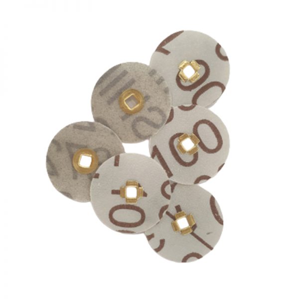 Six scattered 3M Brass Center Aluminum Oxide Sanding Discs marked with brown 100 numbers