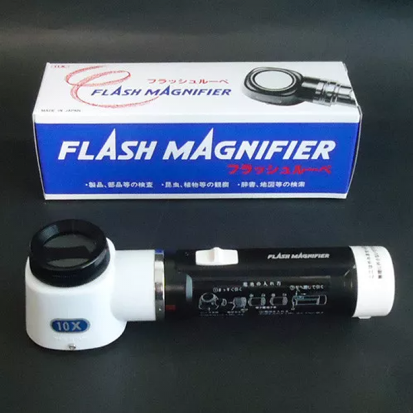 A 10x handheld flash magnifier next to its box, which also displays the "Flash Magnifier" logo