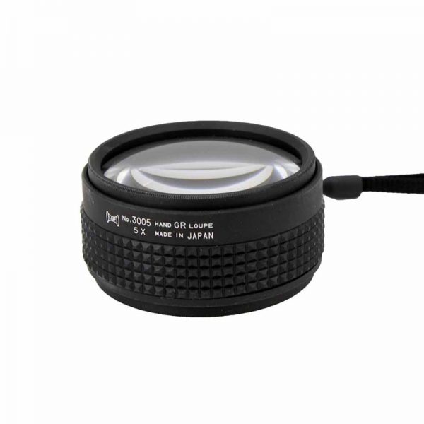 A close-up, low-angle view of the black 5X Hand Grip Loupe, showing the "5 X" and "MADE IN JAPAN" text on its side