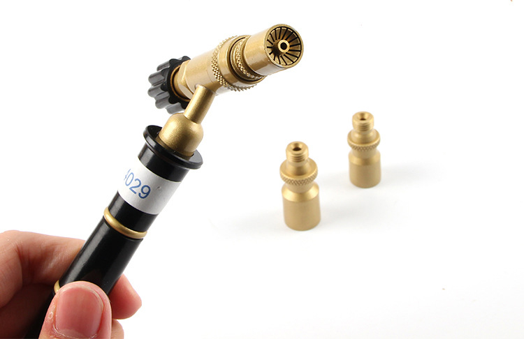A hand holds the ORCA M75 CMF torch with one nozzle attached and the other two nozzles placed nearby