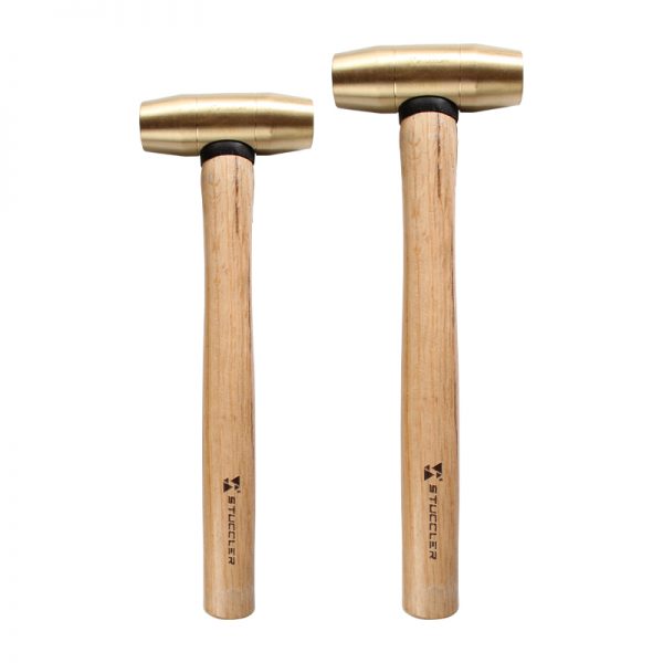 A set of two Stuccler jeweler's brass mallets, a 1lb and a 2lb, standing side-by-side on a white background