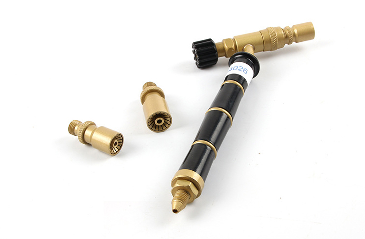 The ORCA M75 CMG torch handle with two of the different-sized nozzles shown detached next to it