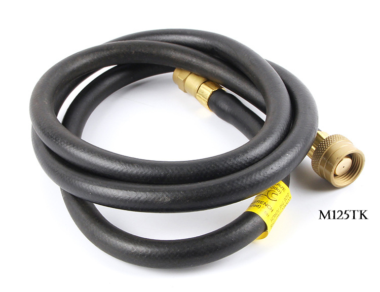 The coiled gas hose for the ORCA M75 CMK torch, with a brass fitting on one end, on a white background