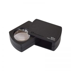 A black Eschenbach pocket magnifier, unfolded to show the 10x lens and an open end.