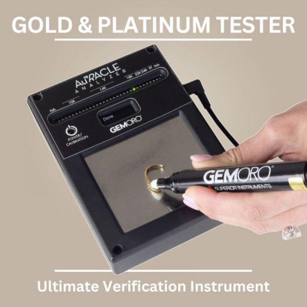 A person using the GEMORO AuRACLE Analyzer, touching the pen probe to a gold ring on the testing plate. The text "Gold & Platinum Tester" is shown.