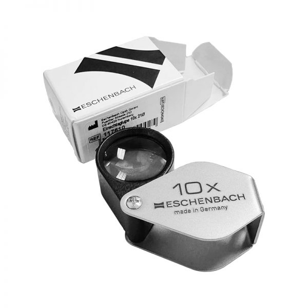 An Eschenbach 10x folding magnifier next to its white and black product box.