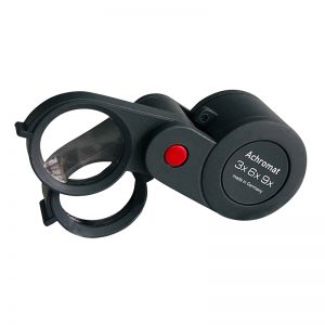 The Eschenbach 1186-9 dual-power folding magnifier, shown fully open with its two lenses and red button.